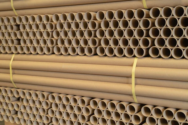 Stack of a bunch of paper tube cores, tissues, in industry manufacturing plant factory. Raw product material of brown paper rolls. Cardboard cylinder cargo pattern in stock workshop storage warehouse.