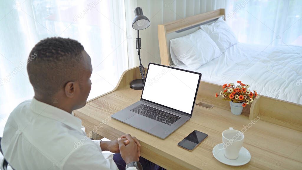 Business black american man, African person working from home on table with computer notebook laptop and blank screen space on webcam video call conference in quarantine in corona virus concept.