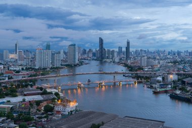 Bangkok 'taki Chao Phraya Nehri' ndeki Taksin Köprüsü 'nün havadan görüntüsü. Tayland. Akıllı kentsel şehrin finans bölgesi. Gökdelen ve gökdelenleri bulutlu ve yağmur fırtınalı yüksek binalar