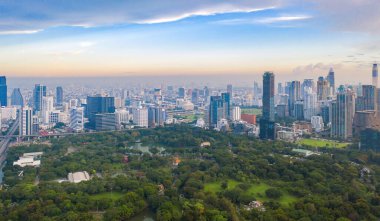 Lumpini Park 'taki yeşil ağaçların havadan görünüşü, Sathorn bölgesi, Bangkok şehir merkezi Skyline. Tayland. Asya 'nın akıllı kentindeki finans bölgesi ve iş merkezi. Gökdelen ve yüksek binalar