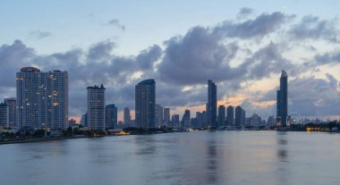 Chao Phraya nehri ile Taksin Köprüsü, Bangkok şehir merkezi. Tayland. Finans bölgesi ve akıllı kentlerdeki iş merkezleri. Gün batımında gökdelen ve yüksek binalar.