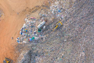 Çevre kirliliğinde endüstriyel fabrikada farklı tipteki dağ çöp yığını, plastik torbalar ve çöp yığınlarından oluşan hava manzarası. Çöp boşaltma alanında atık depolama.