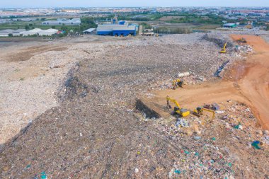Çevre kirliliğinde endüstriyel fabrikada farklı tipteki dağ çöp yığını, plastik torbalar ve çöp yığınlarından oluşan hava manzarası. Çöp boşaltma alanında atık depolama.