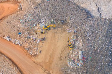 Çevre kirliliğinde endüstriyel fabrikada farklı tipteki dağ çöp yığını, plastik torbalar ve çöp yığınlarından oluşan hava manzarası. Çöp boşaltma alanında atık depolama.