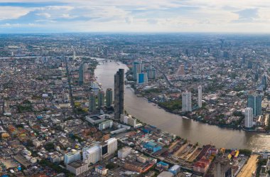 Chao Phraya nehri ile Bangkok şehir merkezinin gökyüzü manzarası. Tayland. Finansal bölge ve Asya 'nın akıllı kentsel kentindeki iş merkezleri. Gün batımında gökdelen ve yüksek binalar.