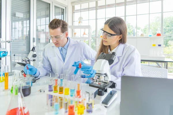 Batılı bir bilim adamı çifti laboratuvar, tıbbi, kimya, sağlık ve araştırma laboratuarlarında kovid-19 virüsü aşısı geliştirmek ve analiz etmek için test tüpü üzerinde çalışıyor. Deneysel bilim.