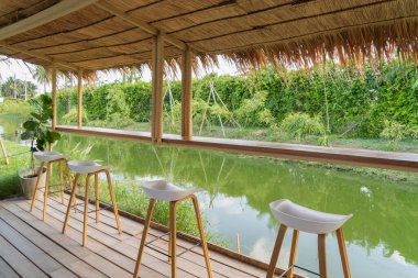 Boş kafedeki teras restoranında tahta sandalyeler. Doğa görüşlü iç tasarım. peyzaj arka planı.