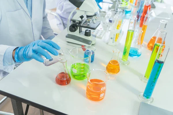 Scientist working on colorful test tube to analysis and develop vaccine of covid-19 virus in lab or laboratory in technology medical, chemistry, healthcare, research concept. Experimental science test