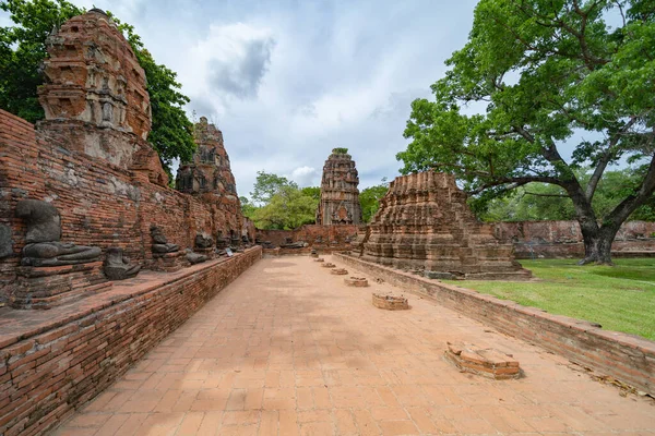 Old ruins of a temple in Phra Nakhon Si Ayutthaya province near Bangkok, Thailand. An old buddha statue in ancient temple. Famous tourist attraction landmark. History of Thai architecture.