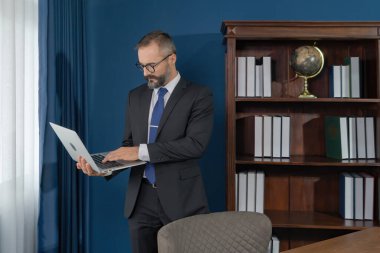 Gülümseyen bir iş adamı, beyaz bir beyefendi, masadan bilgisayarda dizüstü bilgisayarla çalışan beyaz bir adam. Web cam video konferansında. Karantina 'da retro moda tasarımı.. 