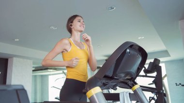 Formda beyaz kadın portresi, beyaz kadın, koşu bandında koşan ya da koşu yapan, spor ve dinlenme konseptinde spor ya da spor salonunda antrenman yapan. Yaşam tarzı etkinliği.