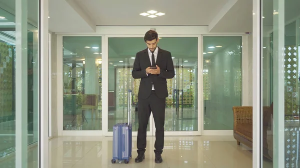 Török Üzletember Bőrönddel Sétálva Folyosóra Mobiltelefonnal Egy Hotelben Üzleti Úton — Stock Fotó