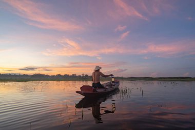 Siluet Balıkçısı, Tayland 'da Asya' da sabah saatlerinde, doğa gölünde ya da nehirde tatlı su balığı yakalamak için ağ atıyor ya da atıyordu. İnsanlar.