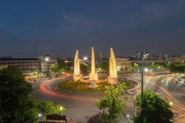 Demokrasi abidesinin havadan görünüşü, bir döner kavşak, Bangkok şehir merkezi ufuk çizgisinde işlek cadde üzerinde araba ışığı patikaları, geceleri şehir merkezi, Tayland. Şehir simgesi mimari manzarası.