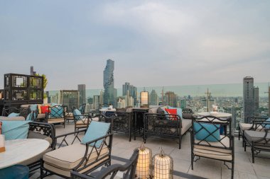 Gökyüzü barı, restoran ya da kafe terası, otelin çatısında yemek masası, şehir merkezi, Tayland 'da şehir merkezi, Bangkok' ta şehir manzaralı yüksek binalar..