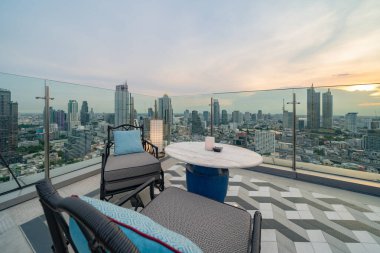 Gökyüzü barı, restoran ya da kafe terası, otelin çatısında yemek masası, şehir merkezi, Tayland 'da şehir merkezi, Bangkok' ta şehir manzaralı yüksek binalar..