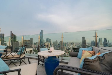 Gökyüzü barı, restoran ya da kafe terası, otelin çatısında yemek masası, şehir merkezi, Tayland 'da şehir merkezi, Bangkok' ta şehir manzaralı yüksek binalar..