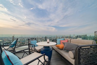 Gökyüzü barı, restoran ya da kafe terası, otelin çatısında yemek masası, şehir merkezi, Tayland 'da şehir merkezi, Bangkok' ta şehir manzaralı yüksek binalar..