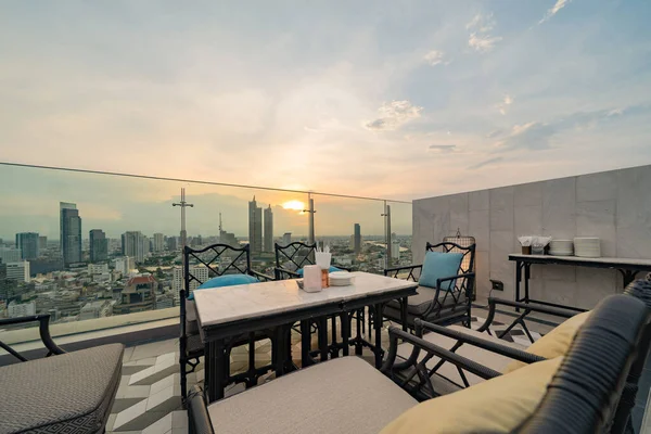 Sky bar, a restaurant or cafe lounge terrace with dinner table on rooftop of hotel, high rise architecture building with city view in Bangkok downtown skyline, urban city, Thailand.