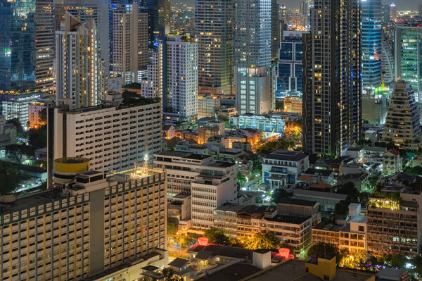 Office buildings windows. Glass architecture facade design with reflection of sky in urban city, Downtown Bangkok City in financial district at night.
