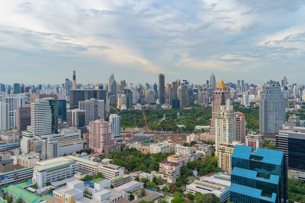 Aerial view of green trees in Lumpini Park, Sathorn district, Bangkok Downtown Skyline. Thailand. Financial district and business center in smart urban city in Asia. Skyscraper and high-rise buildings