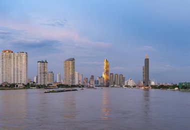 Bangkok, Tayland 'da Chao Phraya Nehri' nin yanında dönme dolap. Finans bölgesi ve gökdelen binaları. Şehir merkezi geceleri gökyüzü.