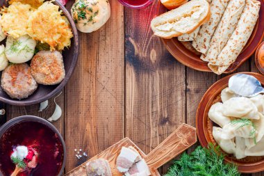 Ahşap bir masa - borsch, vareniki, pampushki sarımsak, domuz yağı, krep, patates, vvar, üstten görünüm, yatay, Ukrayna mutfağından geleneksel yemekleri alanı Kopyala