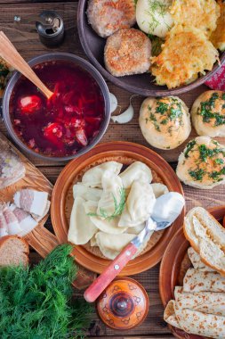 Ukraynalı mutfağı - borsch, vareniki, domuz eti, et suyu, nalgovniki, pirzola Kiev, dranniki, pampushki, seçici odak, ahşap bir masaya geleneksel gıda ana sayfa görünümü