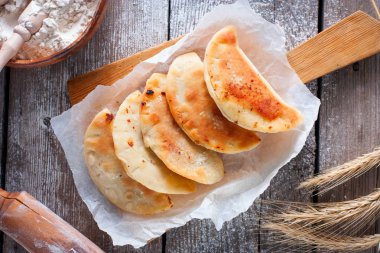 Kızarmış chebureks bir tahta masa, geleneksel Rus yemekleri, üstten görünüm üzerinde