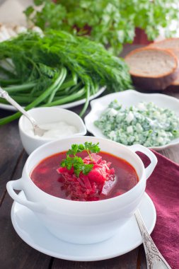 Vejetaryen borsch plaka, seçici odak hizmet veren bir beyaz taze otlar ile