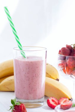 Smoothies Çilek ve muz beyaz bir tablo seçici odak cam bardaklarda