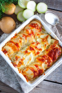 Ahşap bir masa, üstten görünüm üzerinde genç patates ve kabak graten