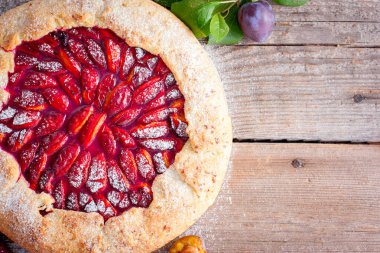 Lor pasta üzerinde Galette'ye ahşap bir masa üzerinde erik ile en iyi görünüm, kopya alanı