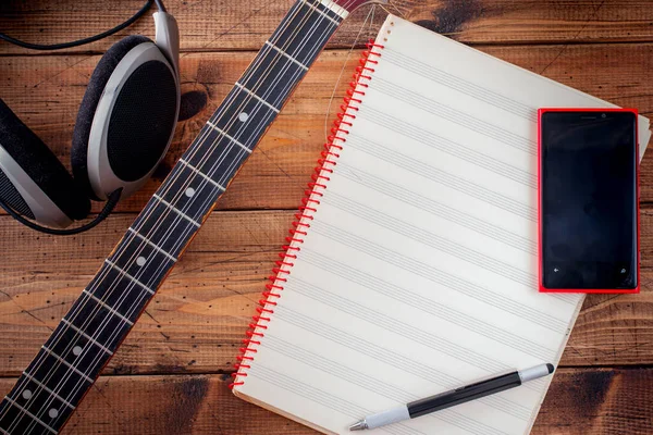 Buzuki, smartphone and clean note notebook on a wooden table, top view, musical concept, copy space