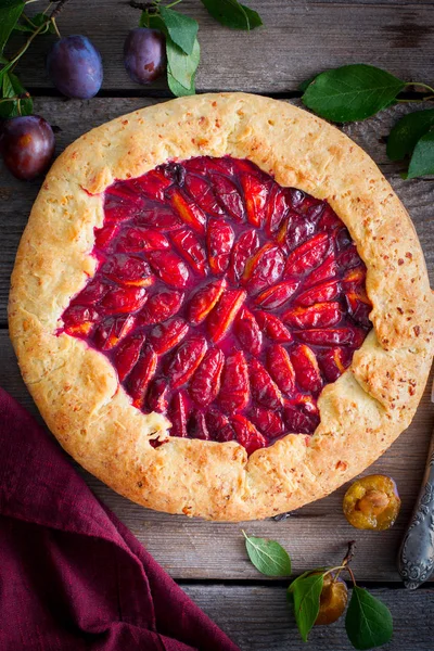 Galette con ciruelas en una mesa de madera, vista superior — Foto de Stock