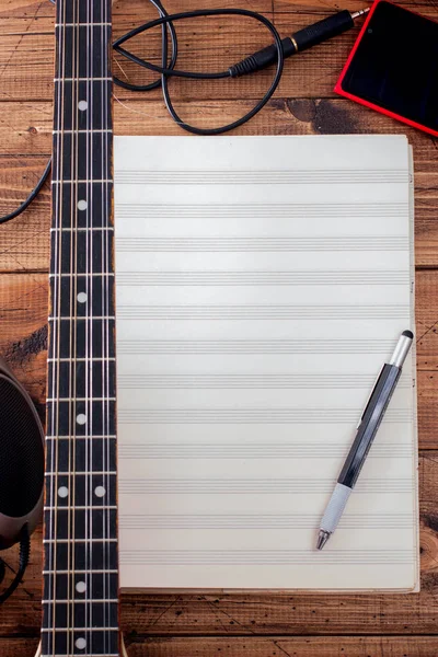 Buzuki, smartphone and clean note notebook on a wooden table, top view, musical concept, copy space