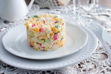 Yengeç salata ile ortaya konulan ayarı, yatay şenlikli bir tabloda hizmet bölümü için beyaz bir tabakta Mısır,