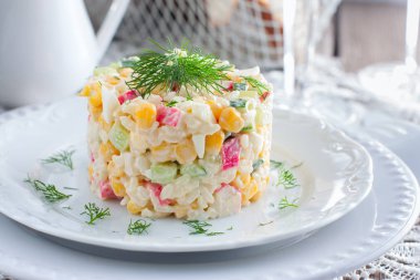 Yengeç salata ile ortaya konulan ayarı, yatay şenlikli bir tabloda hizmet bölümü için beyaz bir tabakta Mısır,