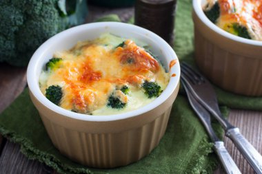 Ahşap bir masa, yatay formlarında porsiyon peynirli brokoli pişmiş