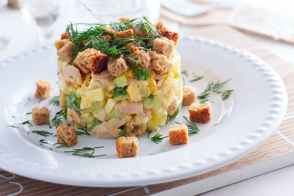 Салат с копченой ветчиной, кукурузой, крекерами на белой тарелке, горизонтальный — стоковое фото
