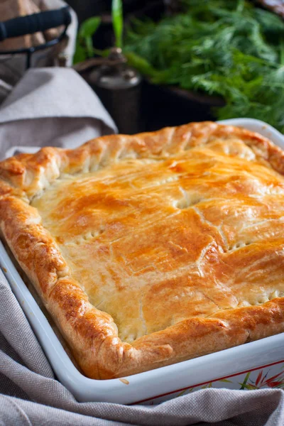 Chicken, potato and onion puff pastry cake, selective focus