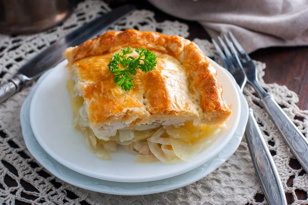 Sliced puff pastry cake with chicken, potatoes and onions, selective focus