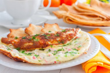 Yengeç omlet beyaz bir plaka üzerinde beyaz ekmek, yatay tost ile sopa.