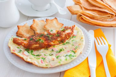 Yengeç omlet beyaz bir plaka üzerinde beyaz ekmek, yatay tost ile sopa.
