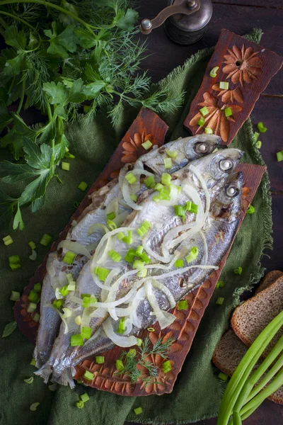 Stewed fish Ryapushka with onions, top view, selective focus