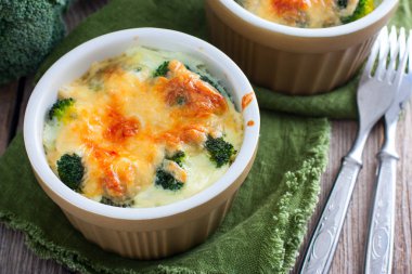 Ahşap bir masa, yatay formlarında porsiyon peynirli brokoli pişmiş