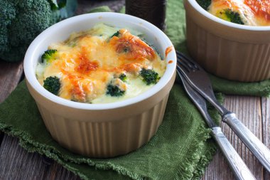 Ahşap bir masa, yatay formlarında porsiyon peynirli brokoli pişmiş