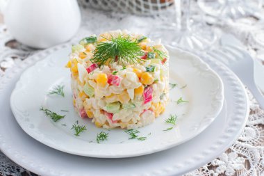 Yengeç salata ile ortaya konulan ayarı, yatay şenlikli bir tabloda hizmet bölümü için beyaz bir tabakta Mısır,