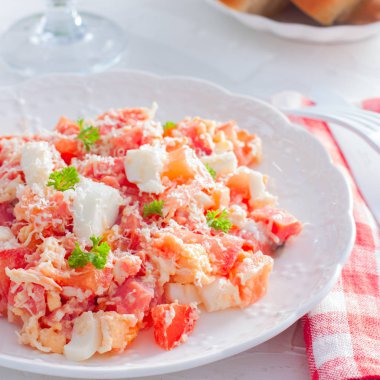 Salata kırmızı balık, domates, yumurta ve peynir beyaz tabakta seçici odak