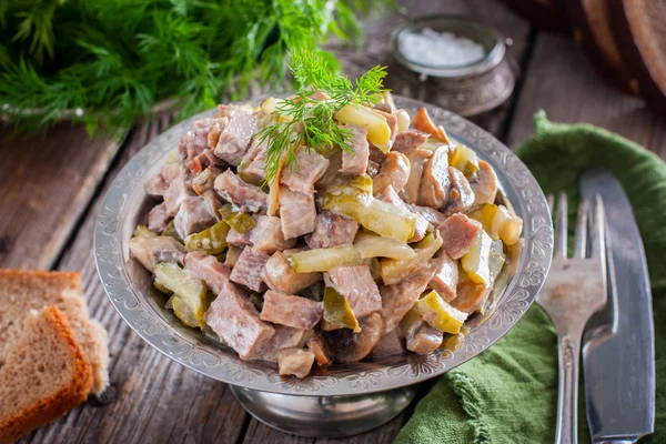 Ensalada con lengua de res, pepinos en escabeche y champiñones sobre una mesa de madera, horizontal — Foto de Stock